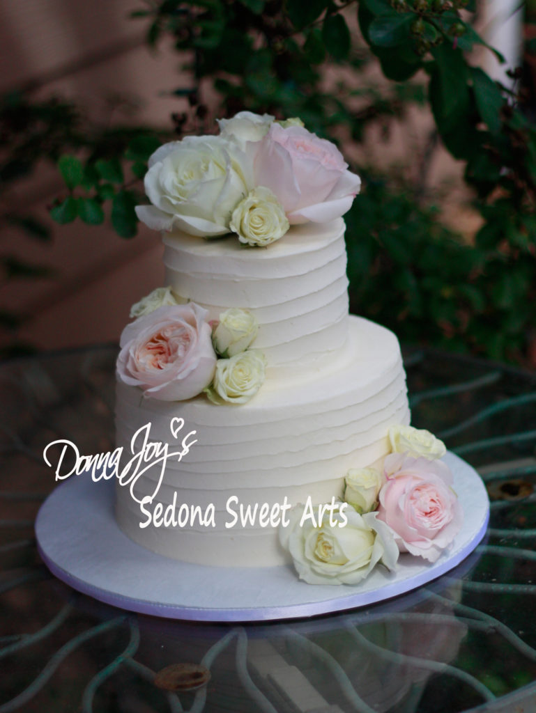 ribbed tuscan wedding cake adorned with fresh flowers