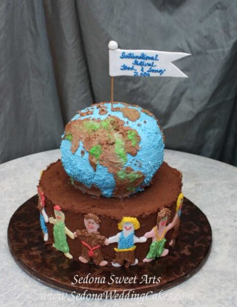 Globe Buttercream cake with international children holding hands on a chocolate cake